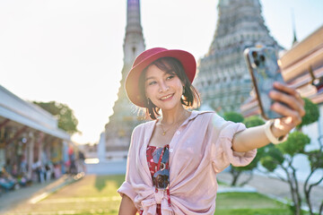 Wall Mural - happy thai woman taking seflie at wat arun temple in bangkok thailand