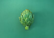 Whole fresh raw artichoke on green background, top view. Space for text