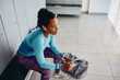 © Drazen - Pensive African American female athlete in dressing room at gym.