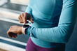 © Drazen - Close up of black athletic woman using smart watch during sports training in gym.