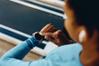 © Drazen - Close up of African American athlete adjusts her fitness tracker while working out in gym.