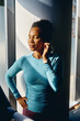 © Drazen - African American female athlete listening music with eyes closed in gym.