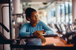 © Drazen - Pensive African American female athlete in gym looking away.