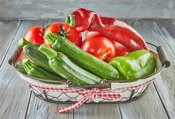 Wall Mural - Zucchini, bell pepper, tomatoes and Red Italian heirloom pepper in basket on wooden background