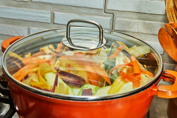 Poster - Pieces of tricolor carrots are cooked in saucepan on gas stove