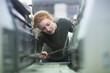 © Cavan Images - Print worker repairing print machine with screw driver