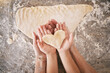 © Lumeez/peopleimages.com - Top view, hands and heart with parent baking with kid, teaching and bonding together, weekend break and loving. Love, family or in kitchen with dough, love or child development with skills or support