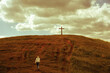 Person walking towards a cross on the hill