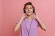 Young short-haired beautiful smiling woman in headphones enjoying music
