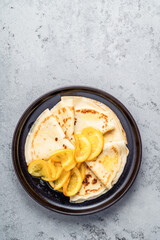 Wall Mural - Plate of crepes with orange on gray background