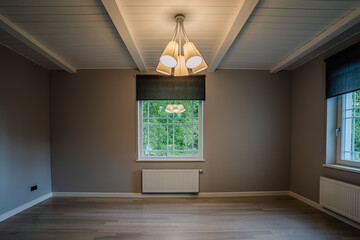 Classical empty room interior. The rooms have wooden floors and gray walls ,decorate with white moulding,there are white window looking out to the nature view.