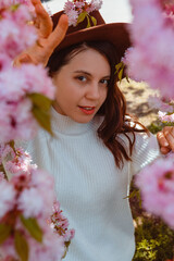 Canvas Print - portrait of beautiful caucasian woman with blooming sakura cherry trees