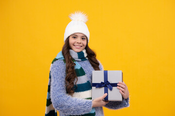 Canvas Print - Teenager child holding gift box on yellow isolated background. Gift for kids birthday. Christmas or New Year present box. Happy girl face, positive and smiling emotions.