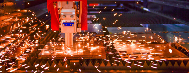 Wall Mural - industrial laser cut machine while cutting the sheet metal with the sparking light.