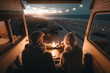 canvas print picture - Couple sitting inside their camper van with open doors looking at the ocean sunset, generative ai