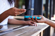 Woman, hands and phone for ecommerce, scanning or transaction on wireless card machine at coffee shop. Hand of customer scan or tap to pay, buy or banking app with smartphone or 5G connection at cafe