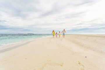 Wall Mural -  Young family on holiday have a lot of fun barefoot on the beautiful beach.