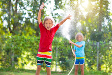 Kids Play With Water Sprinkle Hose. Summer Garden