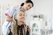 © chachamp - Doctor woman take care smiling older caucasian woman of shoulder massage home