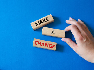Wall Mural - Make a change symbol. Concept words Make a change on wooden blocks. Beautiful blue background. Businessman hand. Business and Make a change concept. Copy space.