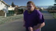 One overweight young man getting back to shape exercising outdoors running during cold day with vapor breath. Motivational discipline concept of losing weight