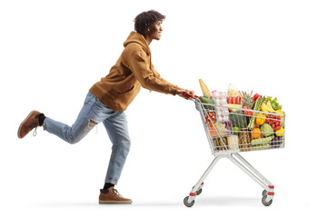 Full length profile shot of a young african american man running with a shopping cart