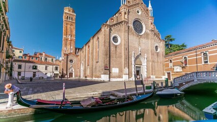 Poster - Basilica di Santa Maria Gloriosa dei Frari timelapse. Bridge, and gondola on canal. This old famous church was built in the 14th century. Blue sky at summet day. Venice, Italy