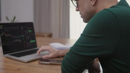 Poster - online trader checking crypto currency graphs on laptop app screen, analist working at home with stock exchange market online