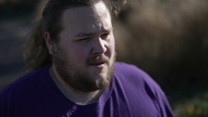 One stressed overweight young man feeling frustration outside in street. A concerned person feeling desperate suffering mental ache. Regret emotion