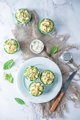 Wall Mural - Spinach Feta cheese breakfast muffins with fresh spinach leaves