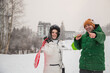 © Myroslava - Beautiful  couple in love spending time outdoor on a snowy winter day, holding sledge red and green.