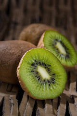 Wall Mural - Juicy fresh ripe kiwi on a wooden table. Kiwi on a textured background.