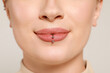 © New Africa - Young woman with lip piercing on white background, closeup