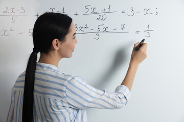 Wall Mural - Young teacher explaining mathematics at whiteboard in classroom