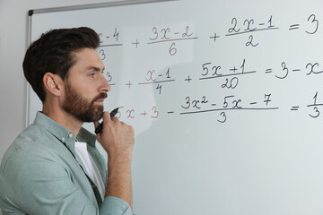 Wall Mural - Mature teacher at whiteboard in classroom during math lesson