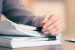 © New Africa - Woman attaching documents with metal binder clip at table in office, closeup