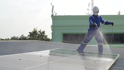 Poster - Technician using high pressure water to clean the solar panels that are dirty with dust and birds' droppings to improve the efficiency of solar energy storage.