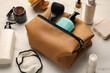 Preparation for spa. Compact toiletry bag and different cosmetic products on white marble table