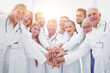 © ASDF - large group of doctors put their hands together.