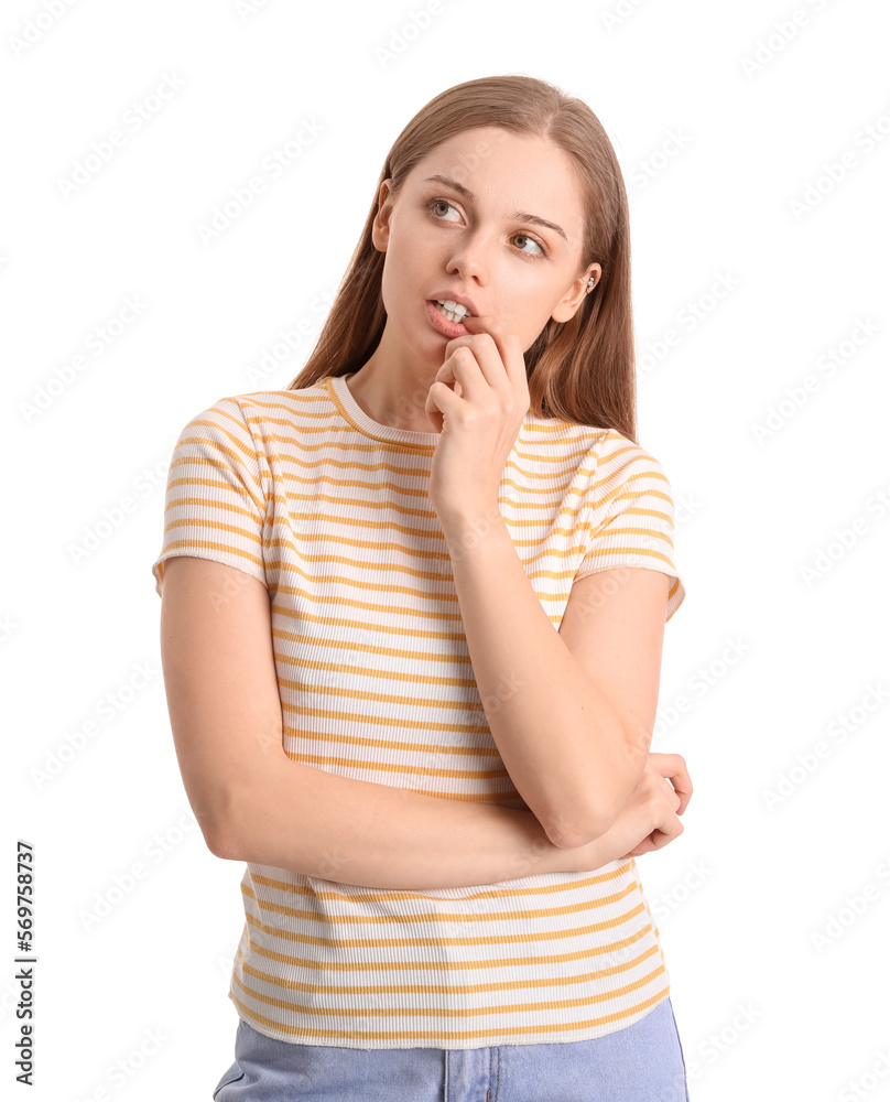Young woman biting nails on white background