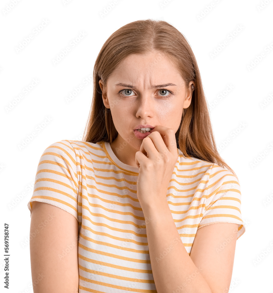 Young woman biting nails on white background