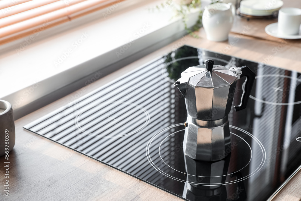 Geyser coffee maker on electric stove in kitchen near window