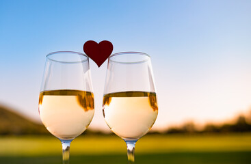 Sticker - Two glasses of wine and heart. Romantic dinner date at sunset. 