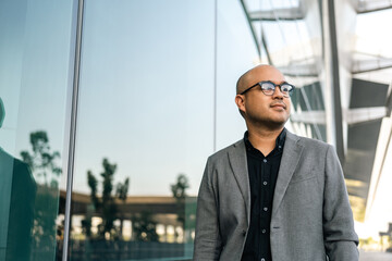 Senior manager business man in suit standing at the buildings downtown. Confident man arms crossed looking towards their goals for success. Executive business man