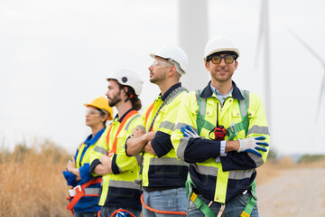 Wall Mural - Portrait of group male and female engineers wear safety uniform and equipment preparing plan inspecting or maintenance of wind turbines at wind farm. Team of engineers working at wind turbines farm