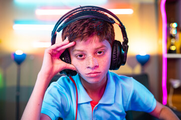 worried kid due to loss in platying video game on computer looking camera at home - concept of cyberspace, competition and entertainment