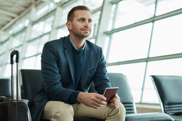 Wall Mural - Airport, passport and business man for travel opportunity, immigration and relax in lobby waiting room for flight. Person or international entrepreneur with identity document and luggage or suitcase