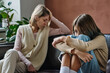 © AnnaStills - Upset teenage girl ignoring conversation with her mother while they sitting on sofa in the room