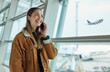 © Nina L/peopleimages.com - Phone call, travel and woman talking at airport, chatting or speaking to contact in lobby. Communication, mobile and happy female with smartphone for networking while waiting for flight departure.