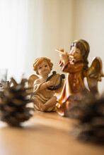Decorative Christmas Angel Figurines With Musical Instruments And Pine Cone On The Table, Bavaria, Germany